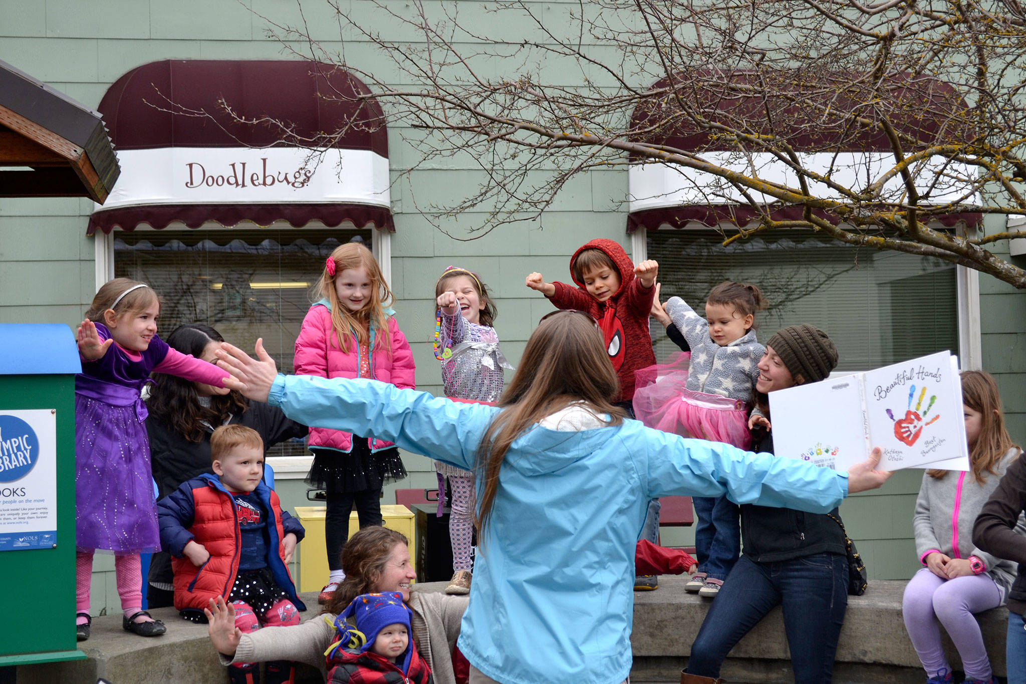 Emily Sly reads &ldquo;Beautiful Hands&rdquo; to a group of families for the &ldquo;Love Sparkle the World&rdquo; project on March 20 in Seal Street Park that encourages families to show children they are loved through reading. Sequim Gazette photo by Matthew Nash