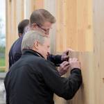 Washington State Rep. Steve Tharinger, foreground, and U.S. Rep. Derek Kilmer put their signature on a cross laminated timber modular building being built on the Greywolf campus. Sequim Gazette photo by Michael Dashiell