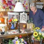 J. Brzoska, owner of The Rusting Rooster, knows a &ldquo;cool find&rdquo; when she sees one. She displays one of her favorites, a clarinet she repurposed into a table lamp. Sequim Gazette photo by Patricia Morrison Coate