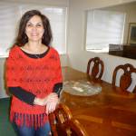 Serenity House Thrift Shoppe manager Belle Muñoz poses with a grand dining room set by Thomasville, originally purchased for $7,000 and now for sale for $2,500 at Serenity Showcase. Sequim Gazette photo by Patricia Morrison Coate