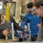 Sequim High School Robotics students, from left, Nick Charters, Riley Chase and Josh King survey a robotic component before a competition in early March. The team qualified for the FIRST Robotics World Championship on April 19-22, in Houston, Texas, and will take their robot there to compete against teams from across the globe. File photo by Patsene Dashiell