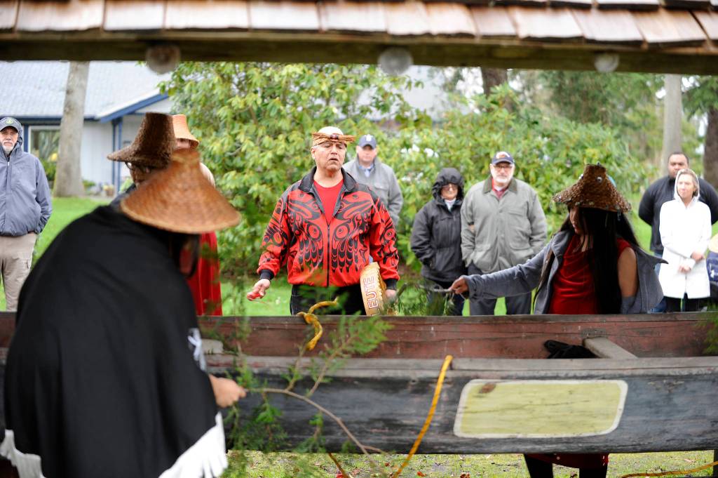 As Vince Penn sings, tribal members bless a canoe before it&rsquo;s removed from Pioneer Memorial Park in Sequim on April 8. Sequim Gazette photo by Michael Dashiell