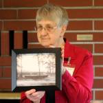 Priscilla Hudson, Sequim Prairie Garden Club member, shows a vintage photo of &ldquo;The Viola,&rdquo; a canoe that spent decades at Pioneer Memorial Park. The canoe was transported to Forks on April 8. Sequim Gazette photo by Michael Dashiell