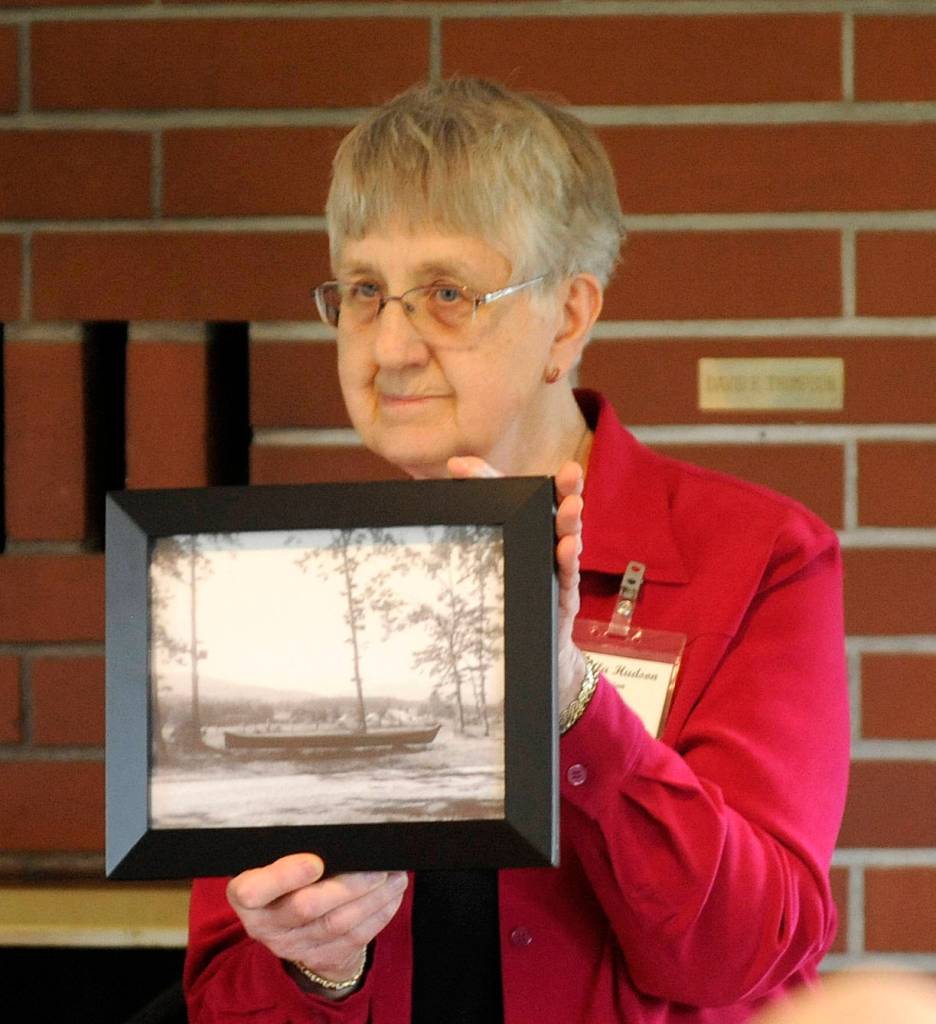 Priscilla Hudson, Sequim Prairie Garden Club member, shows a vintage photo of &ldquo;The Viola,&rdquo; a canoe that spent decades at Pioneer Memorial Park. The canoe was transported to Forks on April 8. Sequim Gazette photo by Michael Dashiell
