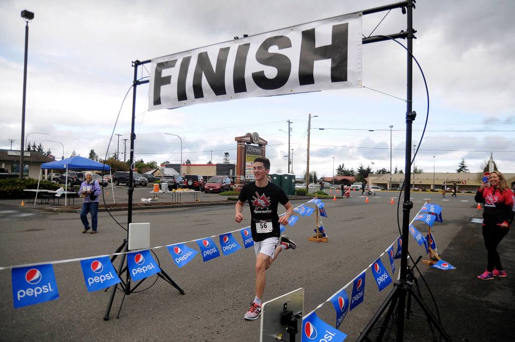 More than 70 participants break from the starting line at Saturday&rsquo;s Sequim Irrigation Festival Fun Run 5k. Crossing hte finish line in first place is Sequim teen Nate Despain. Sequim Gazette photo by Michael Dashiell