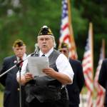 At right, Cmdr. Carl Bradshaw (Sequim American Legion) leads a Memorial Day ceremony at Sequim View Cemetery. At left, Kimball Shelley of Sequim cleans off the marker for his father-in-law, veteran James Davis.