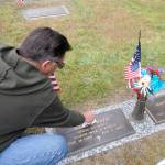 Kimball Shelley of Sequim cleans off the marker for his father-in-law, veteran James Davis. Kimball and Marilyn Shelley said Davis spent his career in the U.S. Navy and helped rescue downed pilots in the Aleutian Islands during World War II. Sequim Gazette photo by Michael Dashiell