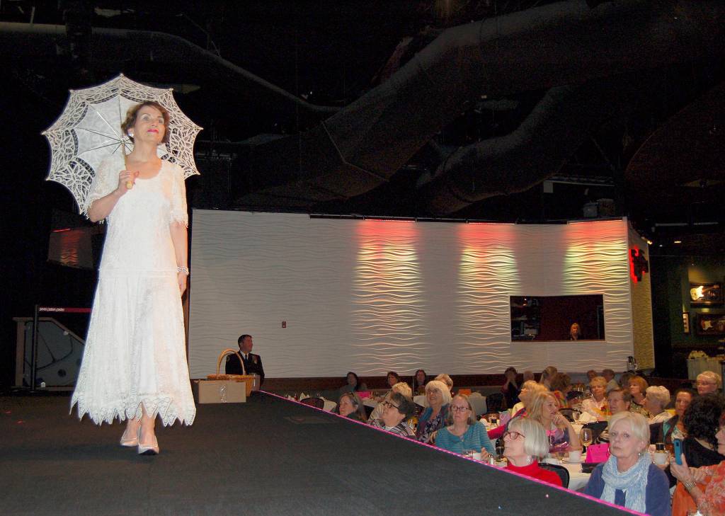 Rebecca Wallace models a lace dress with an umbrella during the Sequim Dungeness Hospital Guild&rsquo;s annual luncheon and fashion show on Thursday, May 11, at the 7 Cedars Casino in Sequim. Sequim Gazette photos by Erin Hawkins
