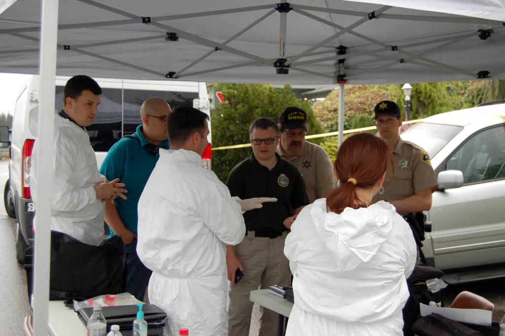 Representatives with the Clallam County Sheriff&rsquo;s Office and Coroner&rsquo;s Office investigate a homicide on the 100 block of Hurricane Drive in Sunland on Thursday, May 4. Sequim Gazette photo by Matthew Nash