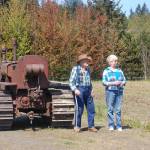Dick Bekkevar, left, stands with Chris Baker as they watch Dave Bekkevar and others conduct the first plow of the season at the Pumpkin Patch in Sequim on Saturday, May 20. Sequim Gazette photo by Erin Hawkins