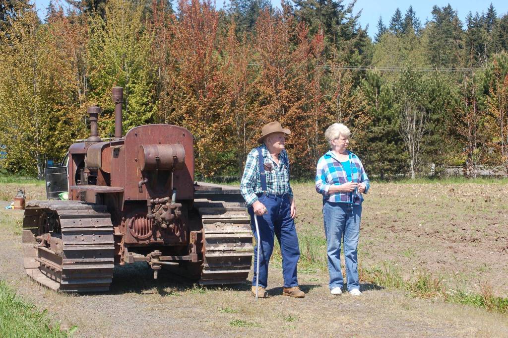 Dick Bekkevar, left, stands with Chris Baker as they watch Dave Bekkevar and others conduct the first plow of the season at the Pumpkin Patch in Sequim on Saturday, May 20. Sequim Gazette photo by Erin Hawkins