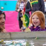 Three-year-old Annabel Lee of Bremerton celebrates a catch in the fish pond with her dad Alexender Lee at the Sequim Irrigation Festival&rsquo;s carnival on Saturday. Sequim Gazette photo by Matthew Nash