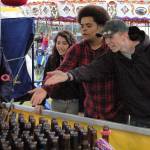 Sequim friends, from left, Anna Laurie, Trevor Jones and Payton Gagnon, all 18, enjoy a round of ring toss at the Sequim Irrigation Festival&rsquo;s carnival on Saturday. It was Gagnon&rsquo;s first time at the carnival, he said, and they all had fun. Sequim Gazette photo by Matthew Nash