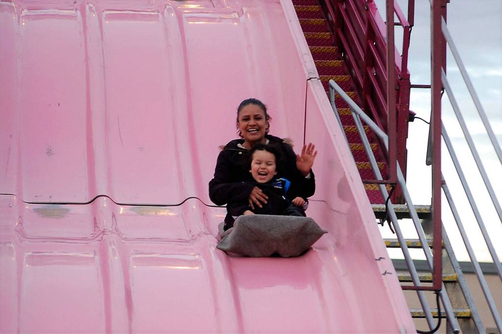 Grandma and grandson Juanita Taylor and Isaiah Loza, 3 1/2, of Sequim, enjoy a quick ride down the Super Slide at the Sequim Irrigation Festival&rsquo;s carnival. Loza said it was their first time down the slide and it was exciting. Sequim Gazette photo by Matthew Nash