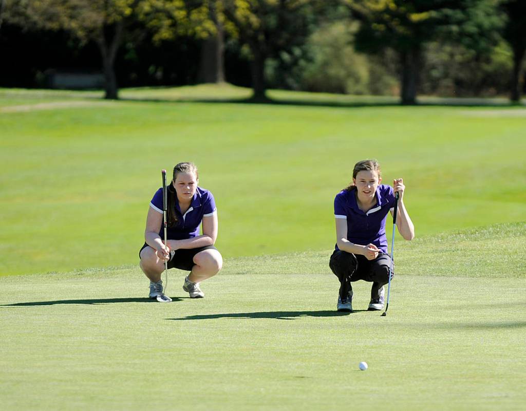 Alex McMenamin, right, and Sarah Shea consider a putt in an Olympic League match in 2016. Sequim Gazette file photo by Michael Dashiell