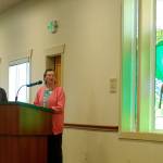 Millie Harrell, on right, created and donated the glass elk to the City of Sequim for its Guy Cole Convention Center remodel. She told a crowd on May 16, including Sharon DelaBarre, chairman of the Sequim Arts Advisory Commission, on left, that she wanted it to stay in Sequim. Sequim Gazette photo by Matthew Nash