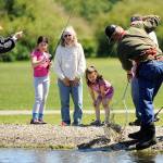 Sadie Miller, 8, of Port Angeles, brings in a fish with help from her mom Amy and Ron Hayes of the Puget Sound Anglers of the North Olympic Peninsula Chapter as her cousin Harper Hilliker, 5, and grandma Bonnie McCloskey watch in anticipation. Sadie and Harper were one of hundreds of children to participate at Kids&rsquo; Fishing Day on May 20 in the Water Reuse Demonstration Park pond north of Carrie Blake Park. Sequim Gazette photo by Matthew Nash