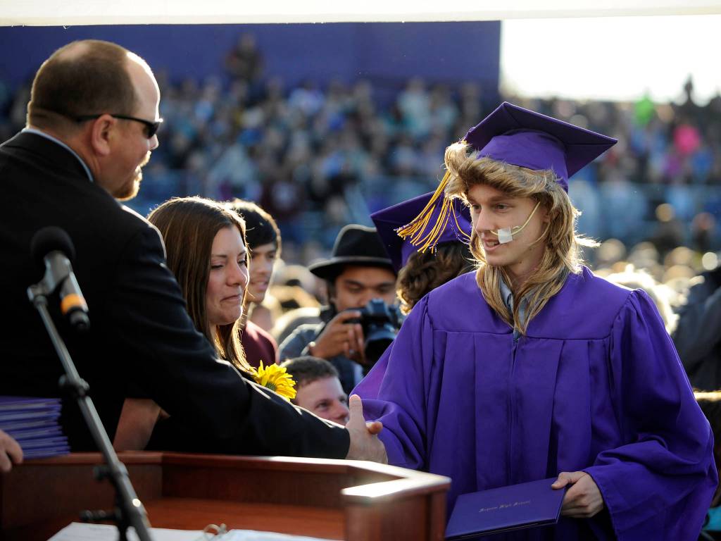 Curtis Beery accepts his high school diploma from Sequim School Board president Heather Short and vice president Brian Kuh at the Sequim High School graduation on June 9. Sequim Gazette photo by Michael Dashiell