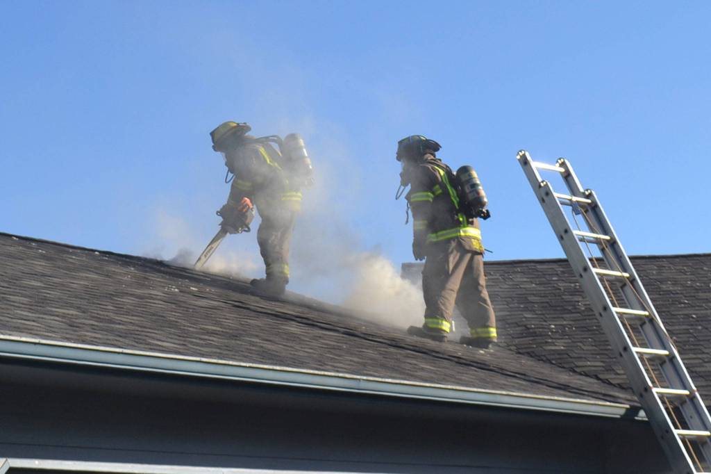 A fire spreads through the attic of a home on the 200 block of Griffith Farm Road on Sunday, June 4. Clallam County Fire District 3 with support from Clallam County Fire District 2 extinguished the fire in about two hours but the damage has displaced the homeowners. Sequim Gazette photos by Matthew Nash