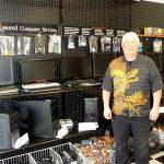 Jim Manderscheid, co-owner of Quality Assured Computer Services, displays a wall full of affordable refurbished computers. Sequim Gazette photo by Patricia Morrison Coate