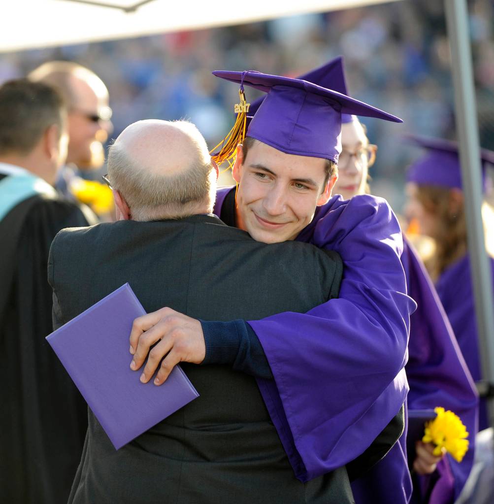 Issaiah Madison gets a hug from Sequim High administrator Randy Hill after receiving his diploma Friday night. Madison was bestowed the school&rsquo;s staff-selected &ldquo;U-Turn&rdquo; award for overcoming obstacles on his way to graduation. Sequim Gazette photos by Michael Dashiell