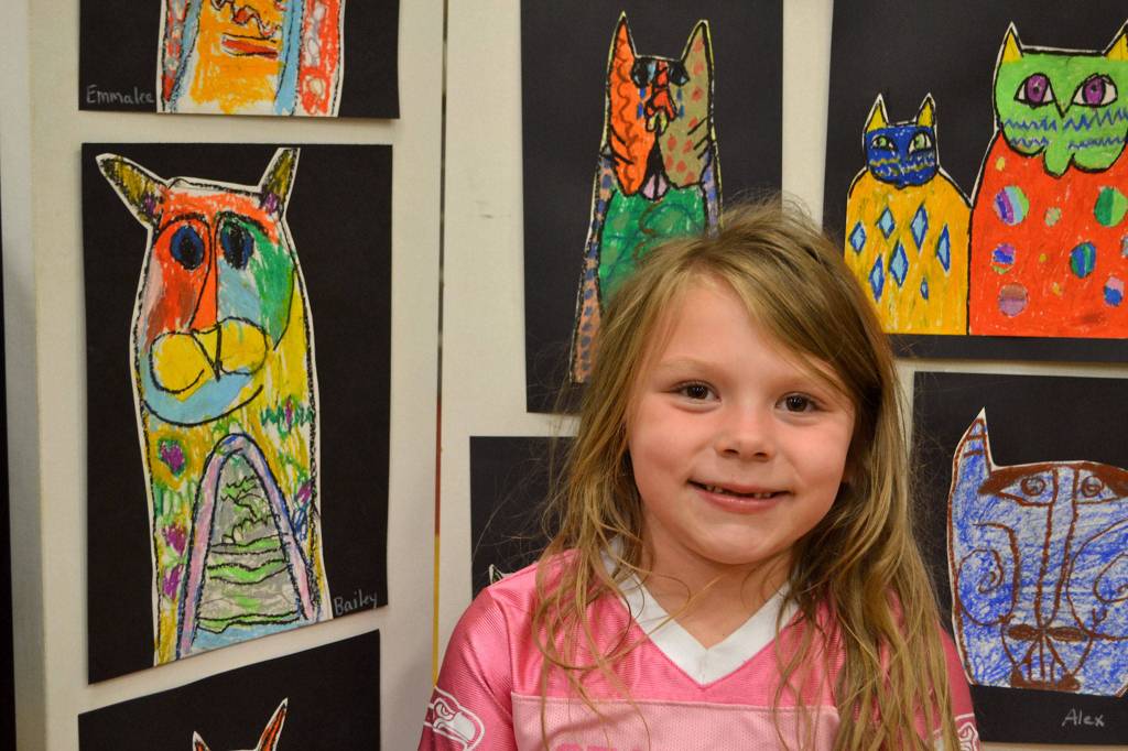 Bailey Fatherson, 6, a kindergartener in Stephanie Grotzke-Nash&rsquo;s class, stands with her art following Laurel Burch. It&rsquo;s her favorite piece, she said, &ldquo;because I like kitties.&rdquo; Sequim Gazette photo by Matthew Nash
