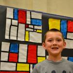 Third-grader Ryan Stites of Rachel Oden&rsquo;s art class stands with his art following Piet Mondrian. He liked it best because he was able to finish it without taking up his class time later in the week. Sequim Gazette photo by Matthew Nash