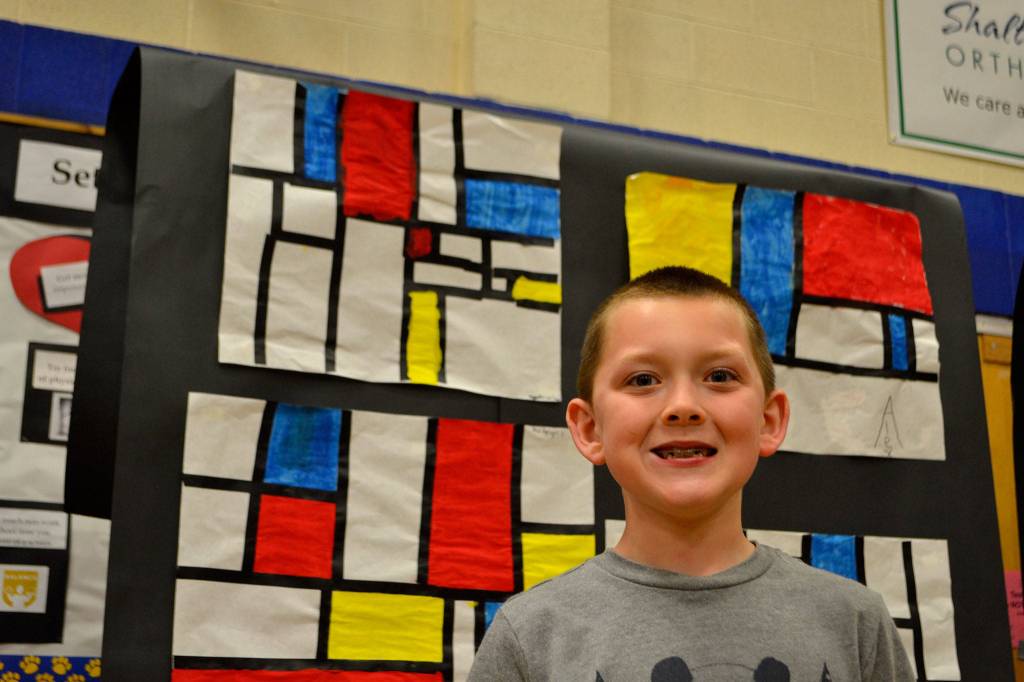 Third-grader Ryan Stites of Rachel Oden&rsquo;s art class stands with his art following Piet Mondrian. He liked it best because he was able to finish it without taking up his class time later in the week. Sequim Gazette photo by Matthew Nash