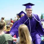 Justin Porter gets and gives high-fives from kindergartners at the Graduation Walk the morning before the SHS commencement ceremony on June 9.