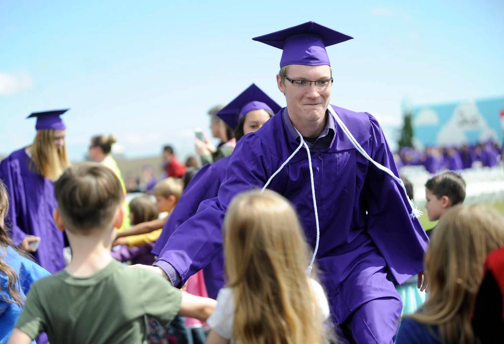Justin Porter gets and gives high-fives from kindergartners at the Graduation Walk the morning before the SHS commencement ceremony on June 9.