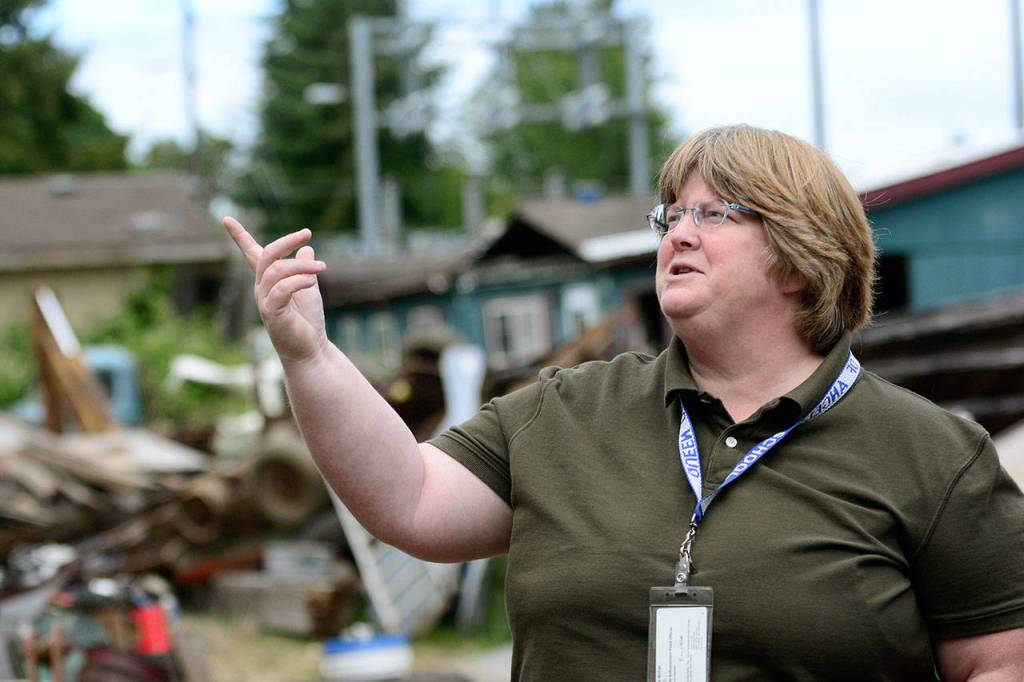 Barb McFall, Clallam County&rsquo;s only code enforcement officer, chats with a homeowner cleaning his property. (Jesse Major/Peninsula Daily News)