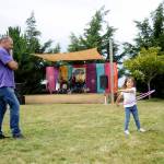 As Joe Ramirez looks on, Taylrin Ramirez, 4, works on her hula hoop skills as Stringology provides the musical backdrop at Jardin du Soleil Lavender on July 21. Sequim Gazette photo by Michael Dashiell