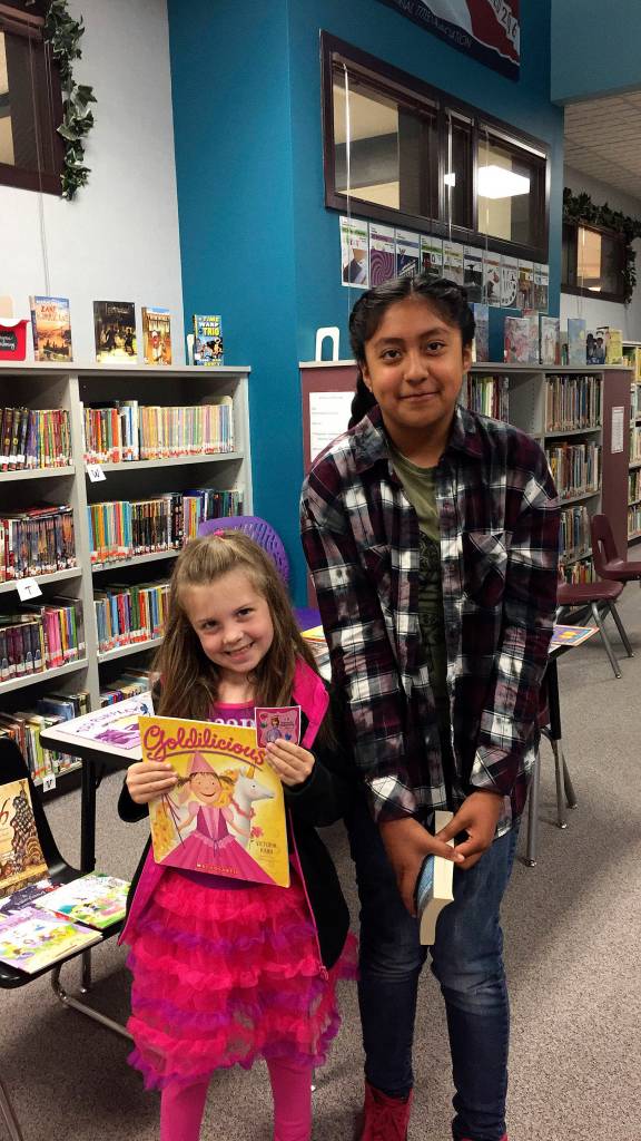 Greywolf Elementary School kindergartener Emma Simpson, left, and fifth-grader Hailey Onofre find a great way to start each day is to find a quiet place and read, by themselves or with a family member. Some students come to the Early Bird Reader program in the school library only occasionally while others like Onofre and Simpson come almost every day. Over the course of the school year, more than 120 different students participated in the Early Bird Reader program. Photo by Katie Salmon-Newton