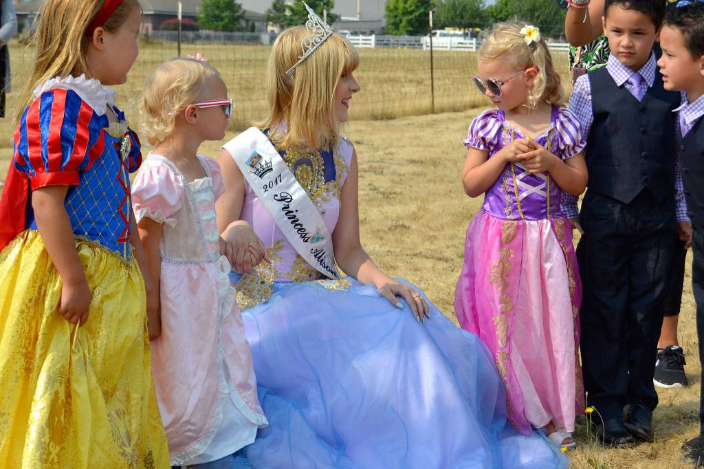 Princess Alison Cobb of the Sequim Irrigation Festival Royalty talks to children after doing the Princess Hokey Pokey at the Sequim Library on Aug. 9. They include, from left, Victoria Kinker, 5, Kimber, 2, and Mazie Konopaski, 4, and Tungston and Tokgnar Davis, 5.