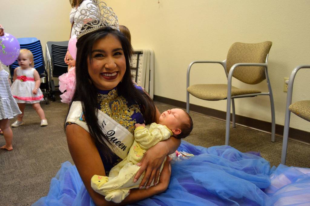 Queen Karla Najera holds 4-week-old baby James Slezak of Sequim.