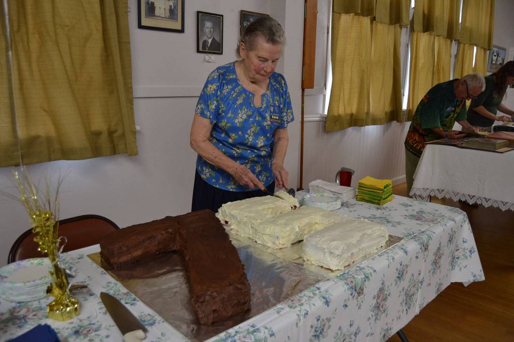 Sue Hargrave, organizer of the Sequim Prairie Grange&rsquo;s 75th anniversary, cuts the cake she made commemorating the occasion on Aug. 9. Sequim Gazette photo by Matthew Nash