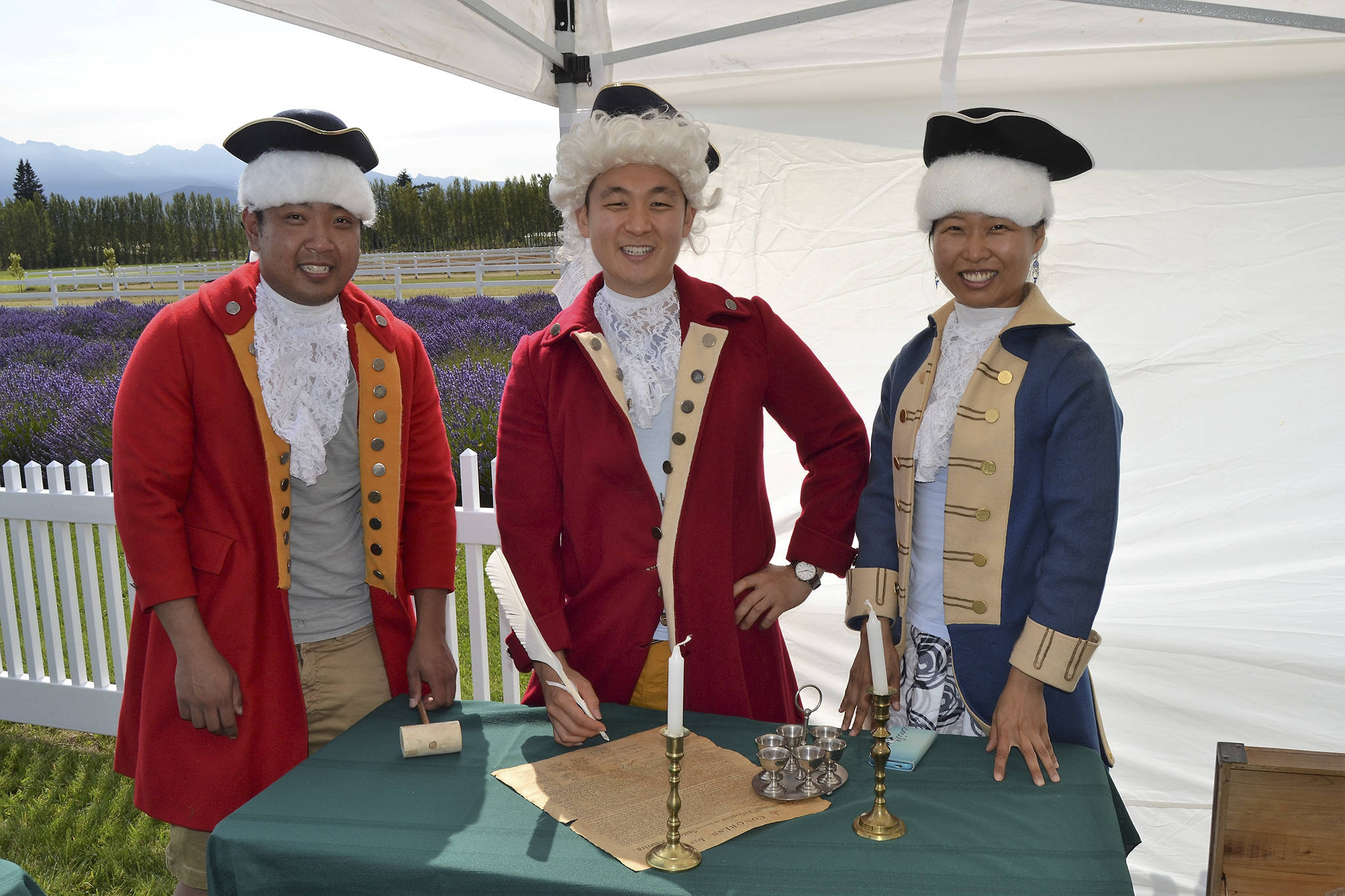 Friends from Seattle, from left, Peter Cher, Jung Jim and Jin Lim dress the part for a photo-op as they prepare to sign the Declaration of Independence. Lim said wasn&rsquo;t able to make Sequim Lavender Weekend so she came up for the NW Colonial Festival. Sequim Gazette photo by Matthew Nash