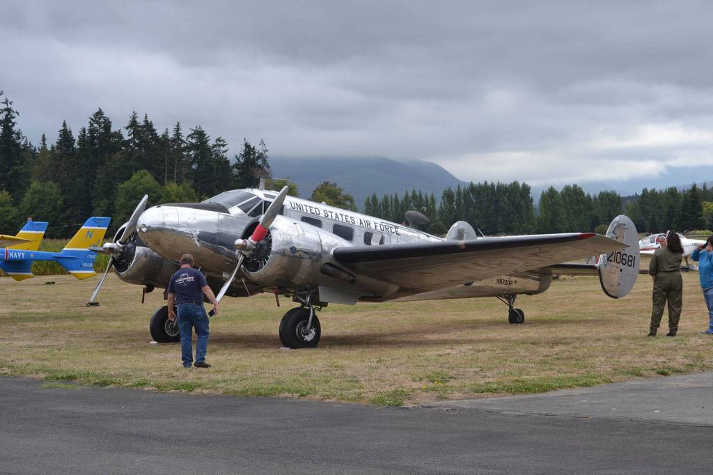 Visitors to the Olympic Peninsula Air Affaire last year admire Neil and Linda Morrison of Port Townsend&rsquo;s Beechcraft C45H that was first delivered to Childress Army Air Field, Texas, on Aug. 26, 1943, to service train bombardiers. Sequim Gazette file photo by Matthew Nash