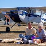 Sequim residents John King, Patti King and their grandson Jack Nunn sit on the grass of Sequim Valley Airport to check out the planes at the Olympic Peninsula Air Affaire.