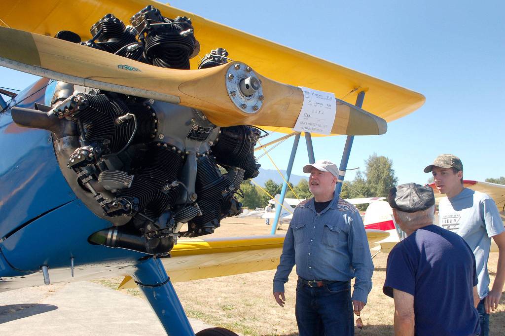 Richard Grennan and Mike Stegriy of Sequim talk with Jacob Kirschbaum, a volunteer with the Port Townsend Aero Museum, about the 1942 PT-17 Stearman restored as a World War II trainer plane on display at the Olympic Peninsula Air Affaire. Sequim Gazette photos by Erin Hawkins