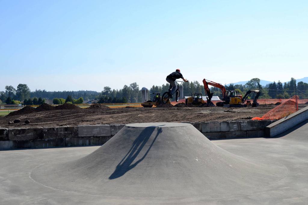 Fifteen-year-old Zach Mueller of Sequim makes a jump at the Sequim Skate Park on Tuesday, Aug. 29, while crews continue to level the Sequim BMX Park to make room for a new entrance to Carrie Blake Park and eight pickleball courts.