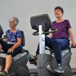 Linda Flores of Port Angeles, left, and Mary Farley of Sequim cycle at the YMCA of Sequim on Aug. 28 during a workout with the Exercise and Thrive program. Sequim Gazette photo by Matthew Nash