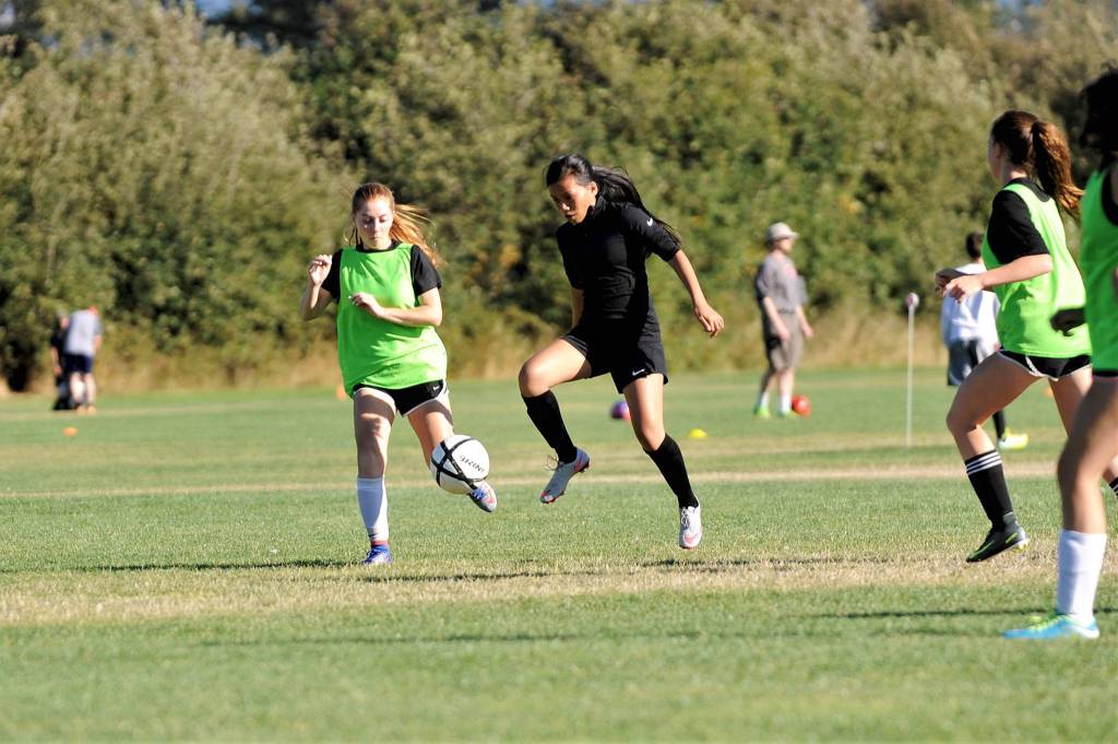 Kristina Mingoy, right, drives past teammate Daisy Ryan in a recent practice. Both girls helped Sequim win 11 games last season, its most ever in the program&rsquo;s history. Sequim Gazette photo by Matthew Nash