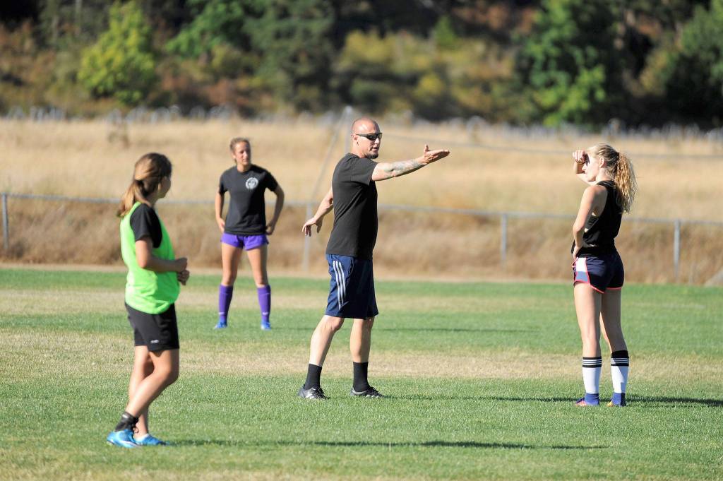 Derek Vander Velde, Sequim girls soccer head coach, seen talking to players at a recent practice, said this season he is pushing new players on the varsity squad to &ldquo;try something new for the benefit of the team.&rdquo; Sequim Gazette photo by Matthew Nash
