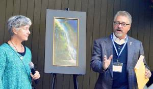 Paint the Peninsula judge Cathe Gill listens as Best in Show winner Bruce Gomez describes painting Olympic National Park&rsquo;s Madison Falls. Gomez was among the artists who won awards totaling $12,000 on Aug. 26, at the Port Angeles Fine Arts Center. Photo by Diane Urbani de la Paz