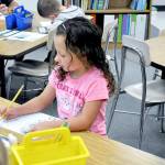 Greywolf Elementary School first-grader Shaye Ball, seated in Leigh Ann Koenig&rsquo;s classroom, is at work on her assignment by 8:32 a.m. Photo by Patsene Dashiell