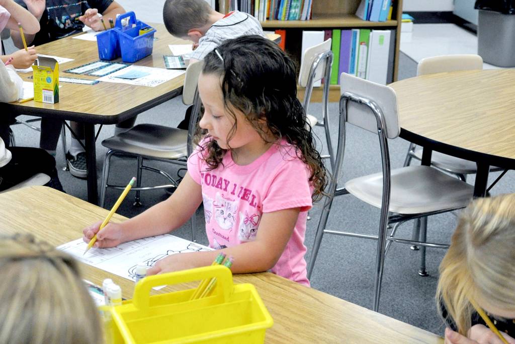 Greywolf Elementary School first-grader Shaye Ball, seated in Leigh Ann Koenig&rsquo;s classroom, is at work on her assignment by 8:32 a.m. Photo by Patsene Dashiell