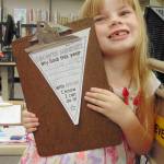 Piper Jackson, a Helen Haller Elementary School first-grade student from Ione Marcy&rsquo;s class, shows that her goal for the school year is to read more books. Photo by Kimberly Bushy