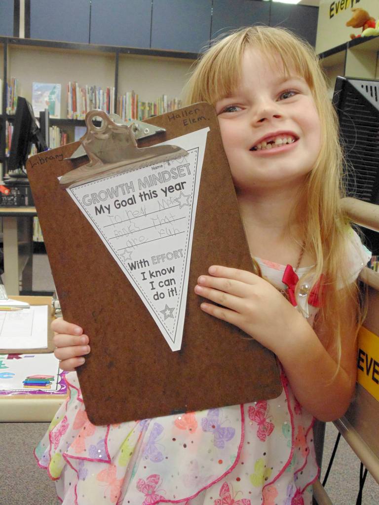 Piper Jackson, a Helen Haller Elementary School first-grade student from Ione Marcy&rsquo;s class, shows that her goal for the school year is to read more books. Photo by Kimberly Bushy