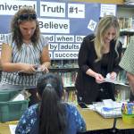 Heather Riley and Sheri Kruckeberg help introduce students and parents to the library during Back to School Night at Helen Haller Elementary School. The library was renovated over the summer to create space for a STEM classroom. As school families flowed through the school campus during the Aug. 29 event, students received stamps from teachers on their &ldquo;passports&rdquo; at each station to earn an ice cream prize in the multi-purpose room. Photo by Patsene Dashiell